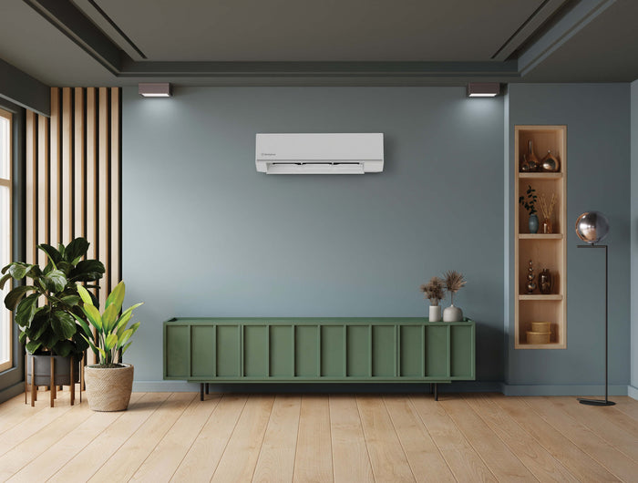 A light blue wall with a green console table below a wall-mounted white air conditioner unit