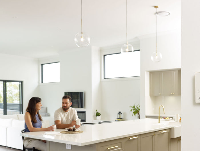 Two people sitting at a kitchen counter in a modern home.