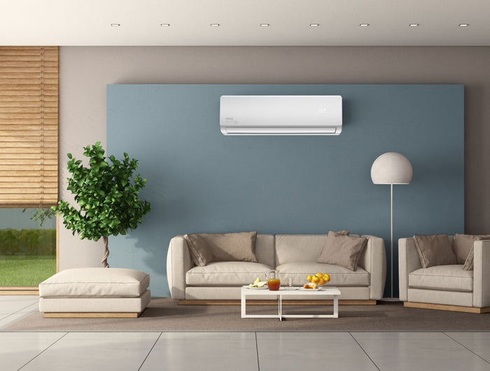 Living room with beige furniture and a light blue feature wall with a TECO wall-mounted air conditioner unit