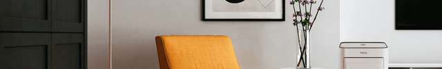 An orange chair in a stylish apartment placed next to a TECO floor air conditioner unit