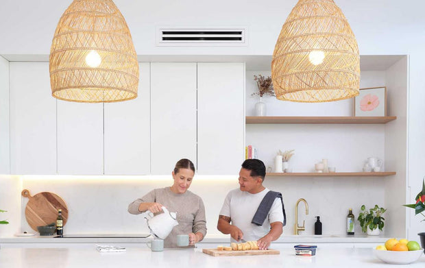 A couple in their white kitchen cooking